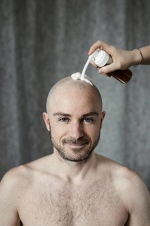 Man gets shaving foam sprayed on his bald head
