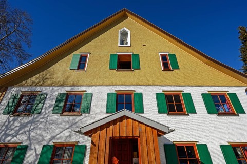 Facade with wooden shingles and figure of the Virgin Mary