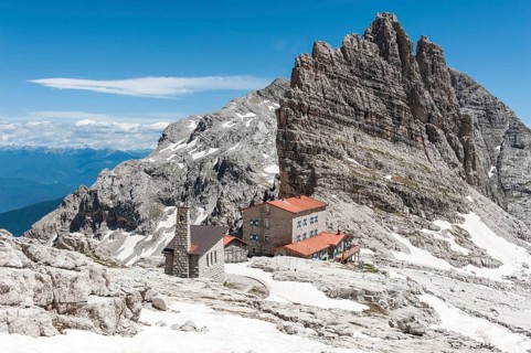 Alpine refuge Rifugio Pedrotti and chapel with rock Croz del Rifugio