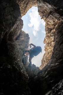 Young woman climbing a steep rock face