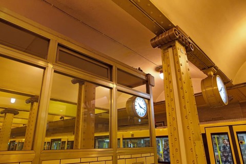 Clock reflected in a pane and steel girders of the underground station Klosterstrasse