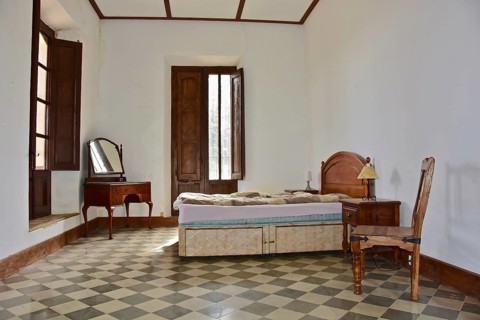 Bedroom with mirrored chest of drawers in bourgeois house in Spain