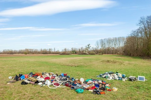 Polluting plastic waste and computer scrap illegally disposed of in a meadow