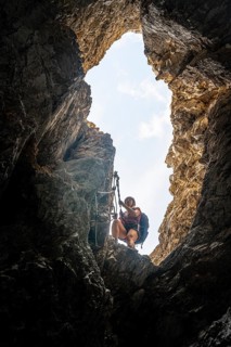 Young woman climbing a steep rock face