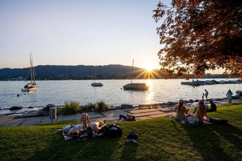 People sunbathing on the shore of Lake Zurich