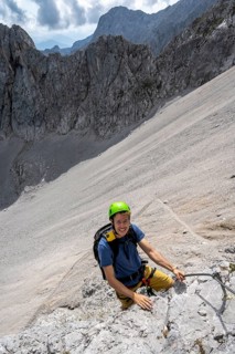Young man climbing in via ferrata
