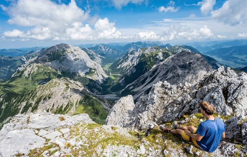 Hiker sitting at the summit of the Lamsenspitze