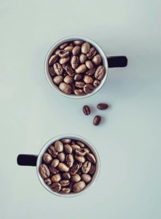 Coffee beans falling into a cup
