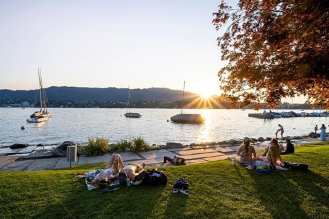 People sunbathing on the shore of Lake Zurich