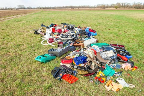 Polluting plastic waste and computer scrap illegally disposed of in a meadow