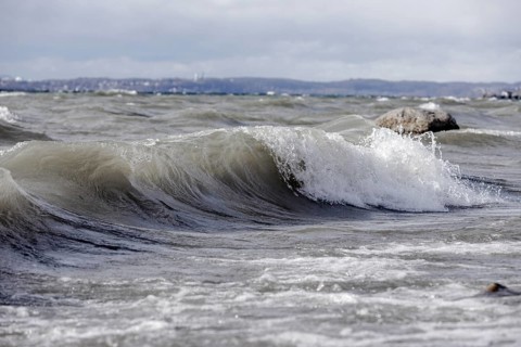 Storm Lolita raging on the rocky shore with waves in Hagnau