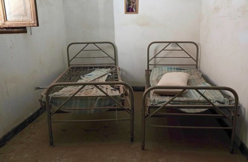 Two metal bedsteads in narrow room