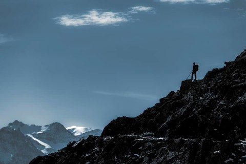 Mountaineers on mountain ridge in the background glaciated mountains