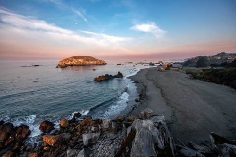 Sandy beach beach Harris Beach with rocks at sunrise