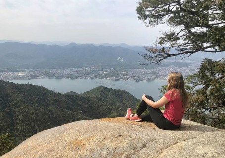 Young woman sitting on a stone