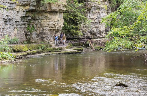 Hiker in front of shell limestone wall in the Wutach Gorge