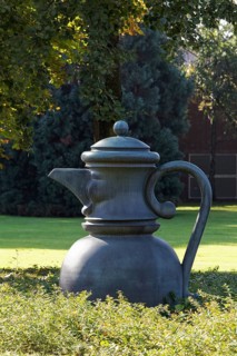 Metal sculpture coffee pot with face