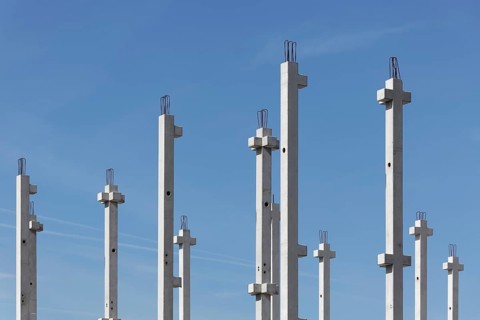 Concrete columns of an industrial hall against a blue sky