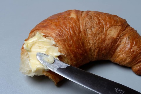 Butter with knife on croissant