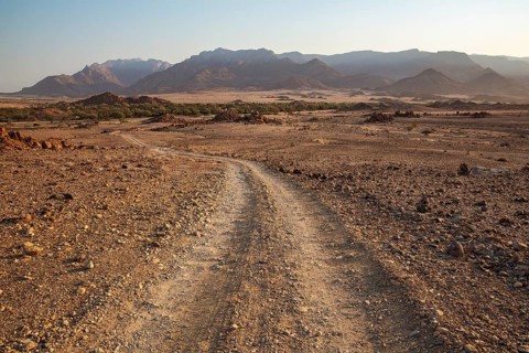 Gravel road towards the dry river bed of the Ugab river
