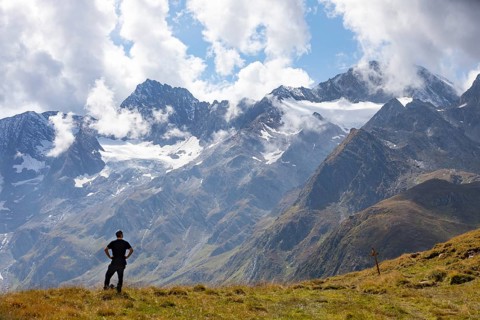 Hiker looking into the mountain massif of the Oetztal Alps in the rear Passeier Valley