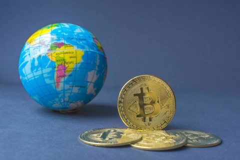 Bitcoin BTC crypto currency gold coins and Earth globe
