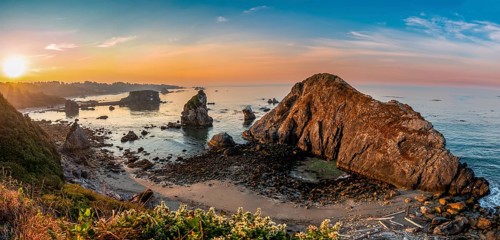 View of sea and sandy beach Harris Beach with rocks at sunrise