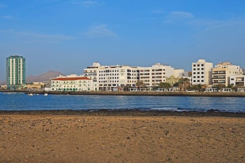 Houses on the harbour promenade with Grand Hotel Arrecife