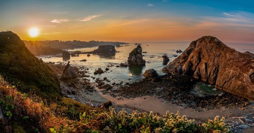 View of sea and sandy beach Harris Beach with rocks at sunrise