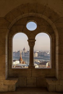 View through an arched window of the Fishermen's Bastion onto the Danube with the Parliament Building