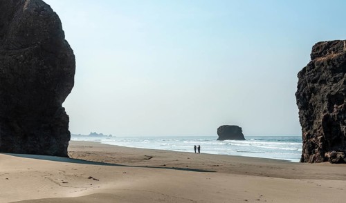 People on the beach between big rocks