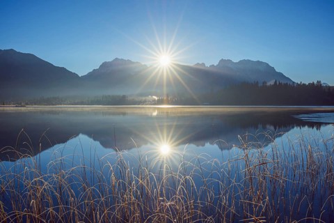 Lake Barmsee with reflected karwendel mountain range and sun