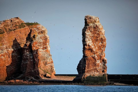 View from the sea to the rocky island of Helgoland with surf pillars Lange Anna and Kleine Anna