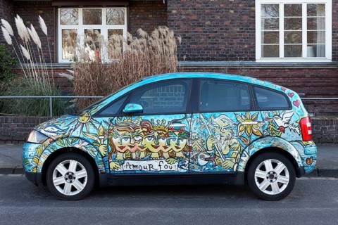 Artistically painted Audi A2 parked in front of residential building