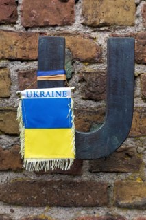 Flag in the national colours of Ukraine hanging from the letter U of Russia
