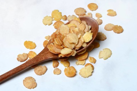 Soy flakes in wooden spoon