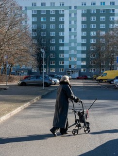 Senior citizen with a walker crossing a street