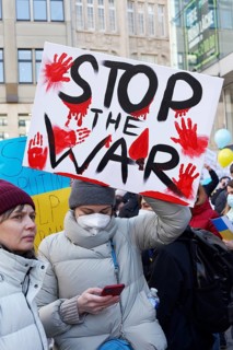 female protestor holds protest poster against the Russian invasion of Ukraine