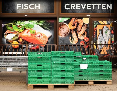 Shop window fish Crevetten in front of it green plastic boxes