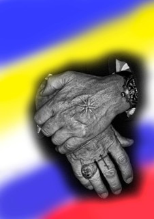 Two hands with tattoos and in the background the flags of Russia and Ukraine