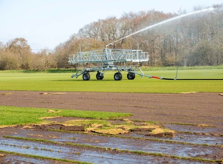 Irrigator machine spraying water turf farming