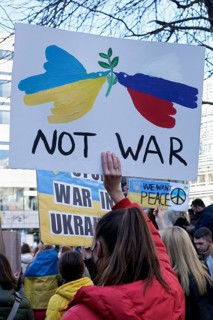 Female protestor holding protest poster against the Russian invasion of Ukraine
