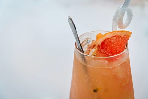 Grapefruit juice in a glass with white background