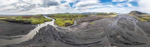 River with fanned out branches through black lava sand