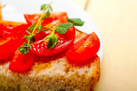 Italian tomato bruschetta with thyme and mint leaves