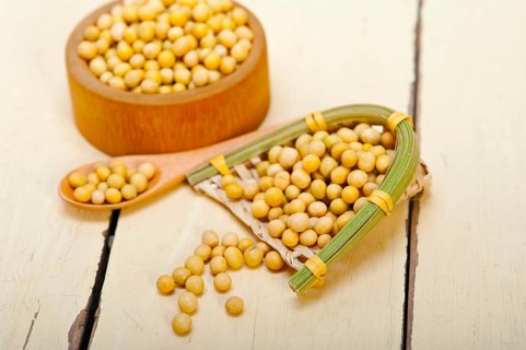 Organic soya beans over rustic wood table macro closeup