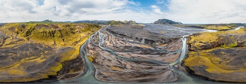 River with fanned out branches through black lava sand