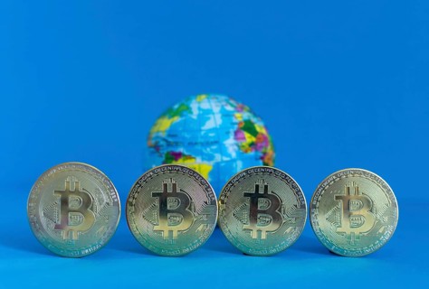 Bitcoin BTC crypto currency gold coins and Earth globe