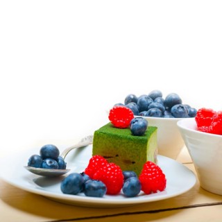 Green tea matcha mousse cake with raspberries and blueberries on top