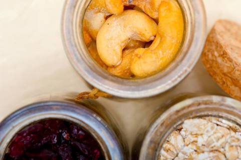 Healthy breakfast ingredients milk oat cashew nuts dried cramberry craisinns